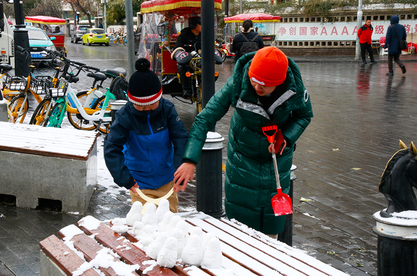 市民和孩子在玩雪。實習(xí)生呂文雅攝