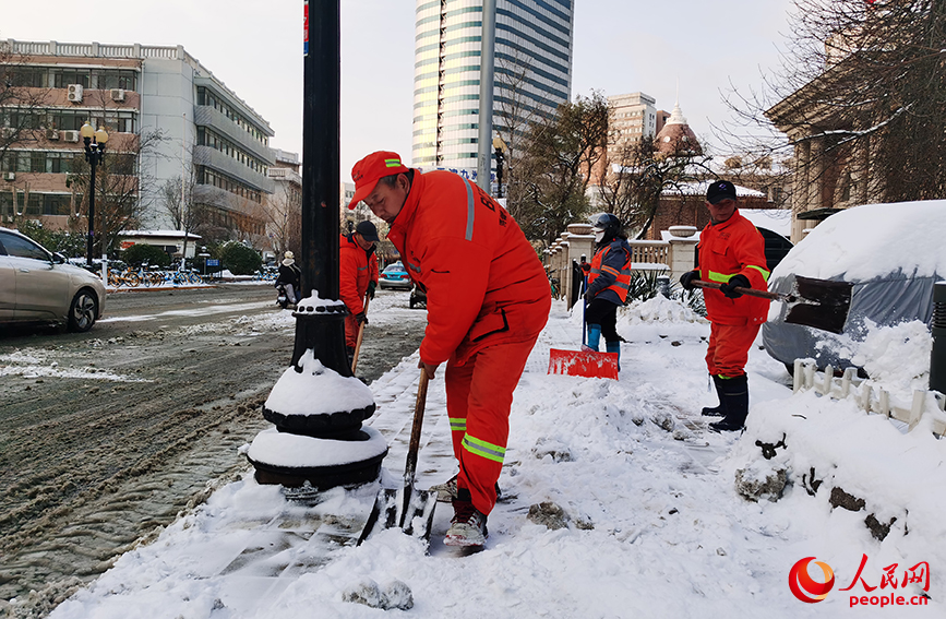 環(huán)衛(wèi)工人正在清理積雪。人民網(wǎng)記者 陶建攝