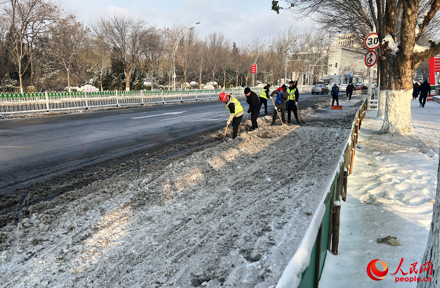 友誼路上，相關人員正在鏟除道路兩側積雪。人民網記者 張靜淇攝