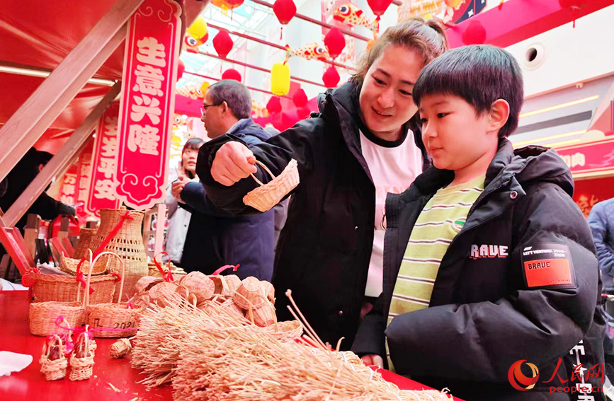 市民在“竹編草編技藝”攤位前駐足，沉浸式感受來源于生產(chǎn)生活實(shí)踐的非遺傳統(tǒng)技藝。人民網(wǎng) 郭維瑾攝