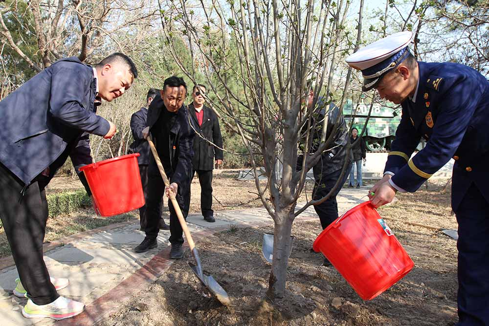 參加活動人員在天津市烈士陵園植樹澆水。梁永攝