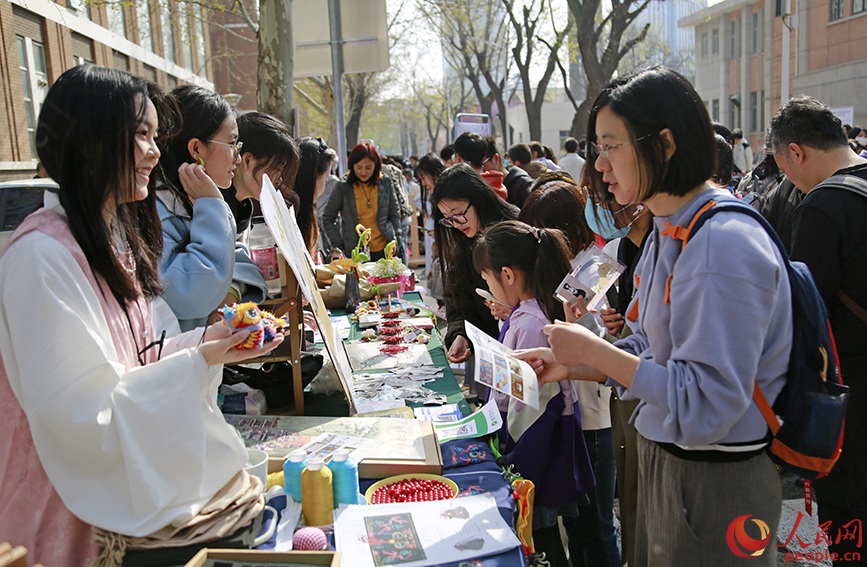 海棠樹下，天大學(xué)子向游客展示中國傳統(tǒng)手工制品。人民網(wǎng)記者 崔新耀攝