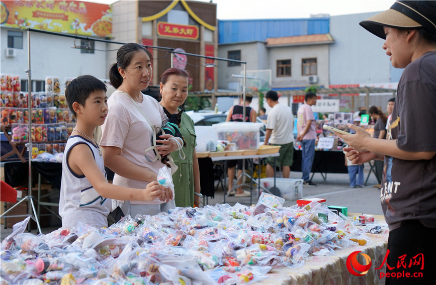 市民帶著孩子挑選玩具。人民網(wǎng)記者 孫一凡攝