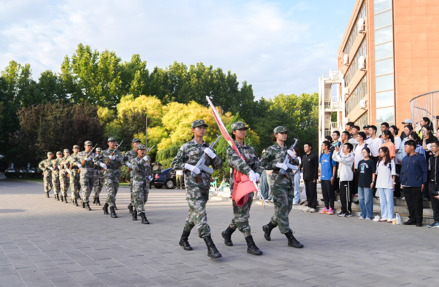 南開大學(xué)國(guó)旗護(hù)衛(wèi)隊(duì)邁著整齊的步伐，以莊嚴(yán)姿態(tài)護(hù)衛(wèi)國(guó)旗走至升旗臺(tái)。宗琪琪攝